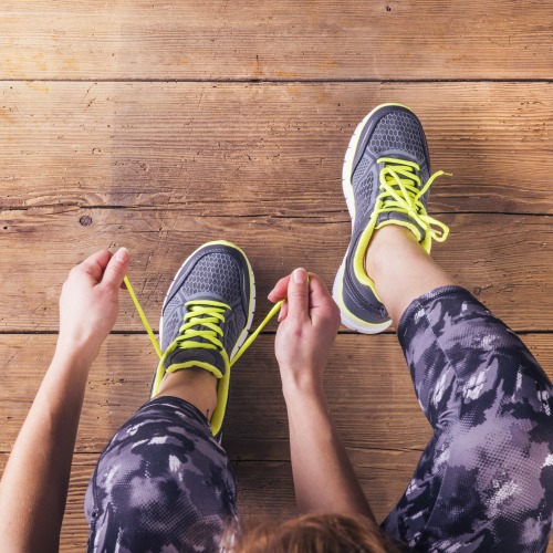 Runner tying trainers on a wooden floor